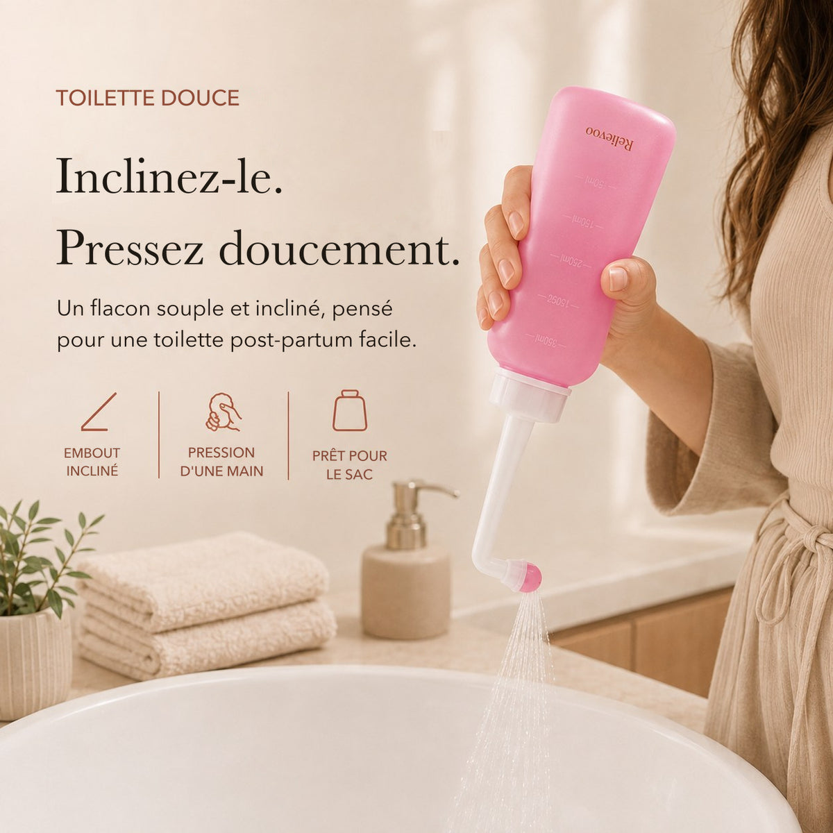 Main pressant le flacon rince-périnée rose Relievoo de 350 ml à embout incliné