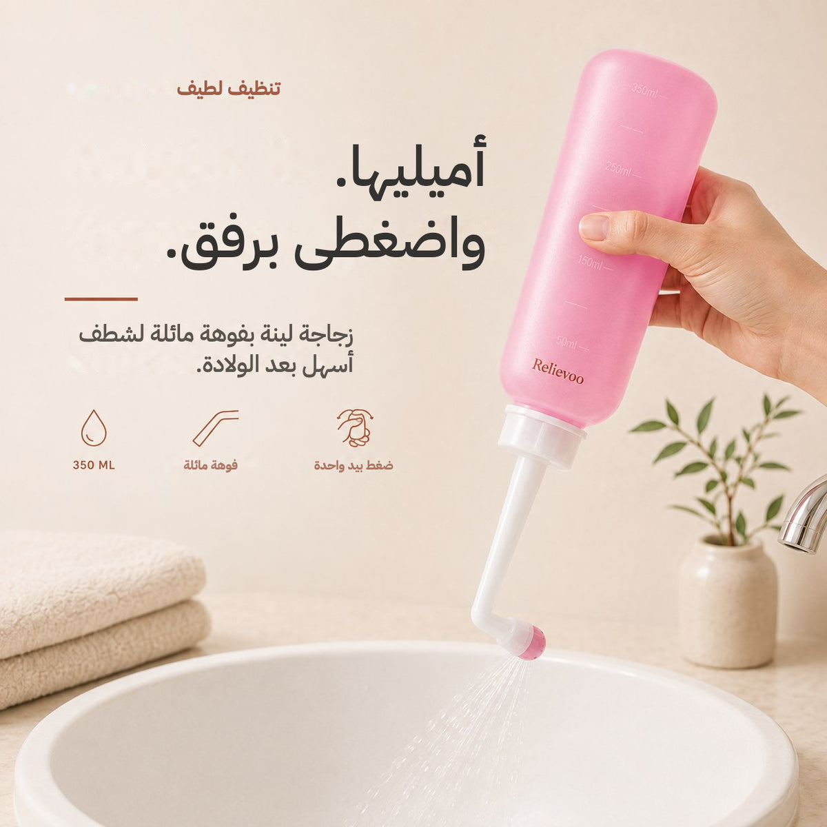 Hand squeezing the pink 350 ml Relievoo peri bottle with its angled nozzle over a basin