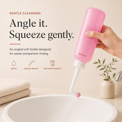 Hand squeezing the pink 350 ml Relievoo peri bottle with its angled nozzle over a basin rvpumpen rvhasar