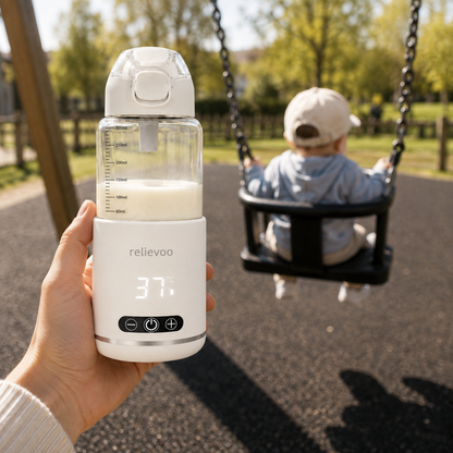 Mum holding the Relievoo bottle warmer at the playground while her baby swings