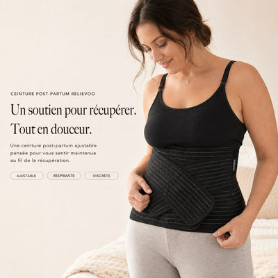 Femme portant la ceinture de maintien post-partum Relievoo noire sur un débardeur noir, la main sur la sangle avant