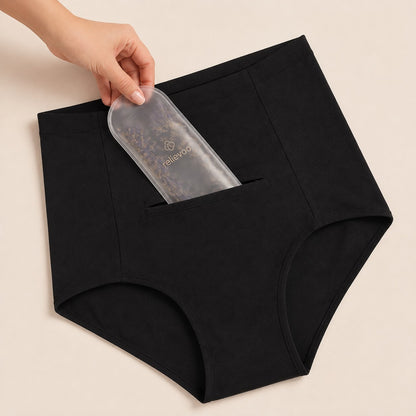 Hand sliding the lavender hot & cold therapy pack into the hidden front pocket of the black postpartum briefs