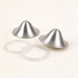Two brushed silver nursing cups photographed at an angle beside their two clear silicone sealing rings
