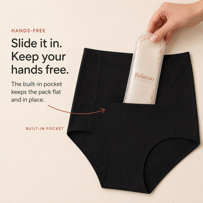 Hand sliding the Relievoo therapy pack into the built-in front pocket of black postpartum briefs