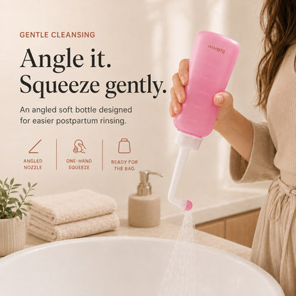 Hand squeezing the pink 350 ml Relievoo peri bottle with its angled nozzle rvpumpen
