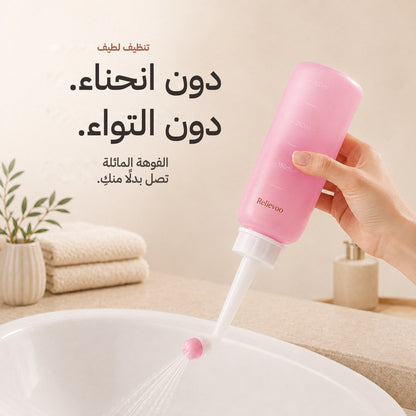 Hand holding the pink 350 ml Relievoo peri bottle with its angled nozzle over a basin