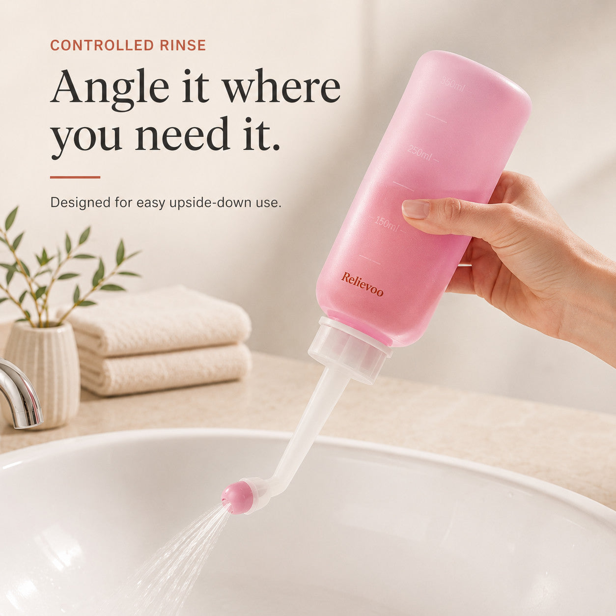 Hand holding the Relievoo peri bottle upside down and rinsing over a basin