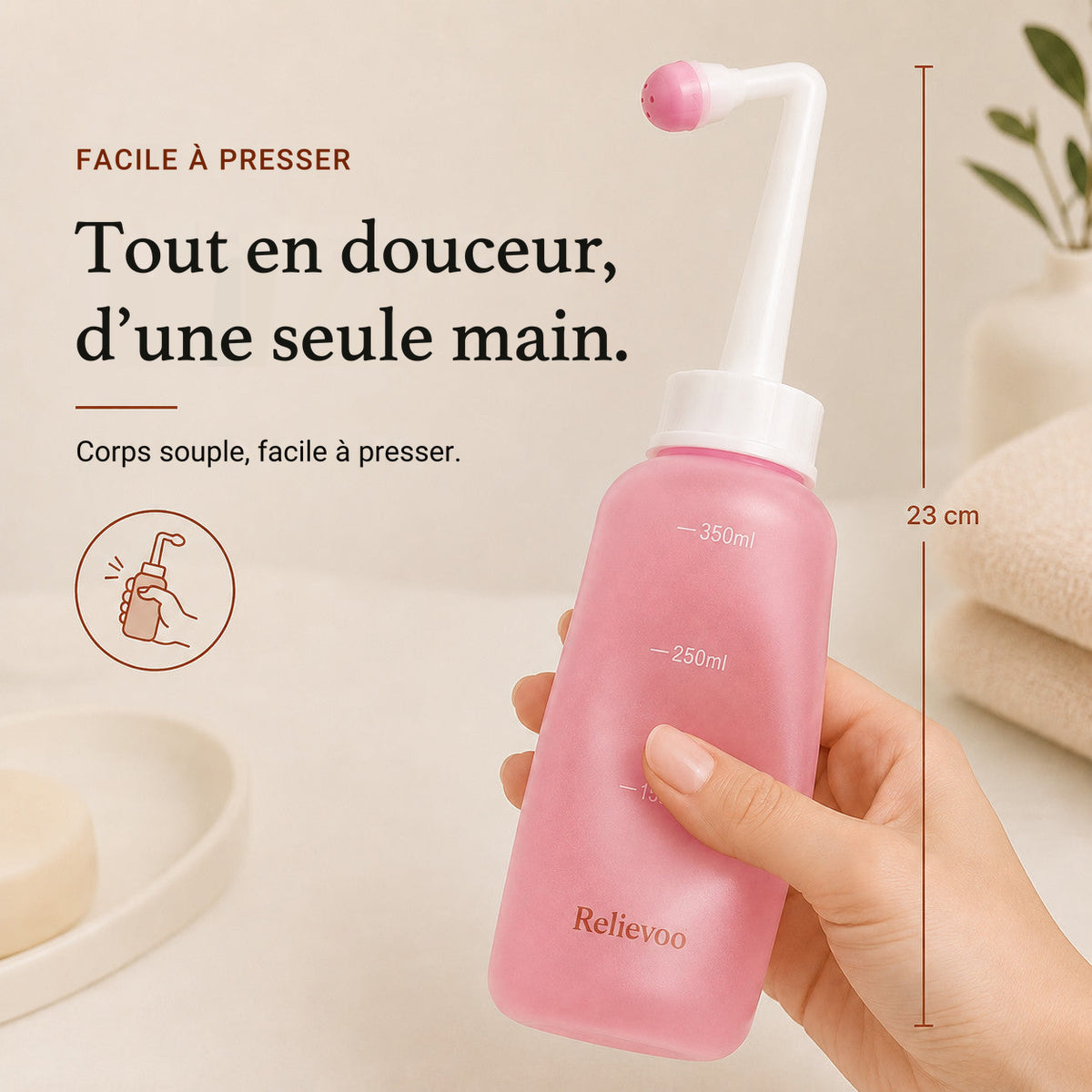 Main pressant d’une seule main le flacon rince-périnée Relievoo de 23 cm