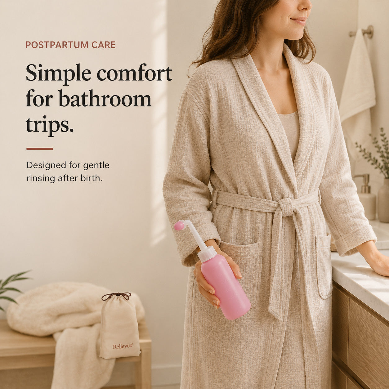 Woman in a bathrobe holding the Relievoo peri bottle in a bathroom, travel pouch on the bench